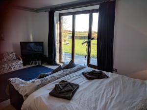 a bed in a room with a large window at The Old Rectory in Amlwch