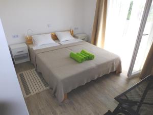 a bedroom with a bed with a green object on it at Apartmani Berno in Starigrad-Paklenica