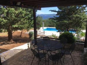 une terrasse avec une table, des chaises et une piscine dans l'établissement Villa Pinia Holiday home with a pool, à Jadranovo