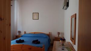 una camera da letto con un letto blu e un tavolo di Affittacamere S' Eremu a Dorgali