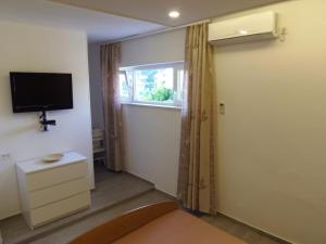 a room with a television and a door with a window at Villa Nobilo in Lumbarda