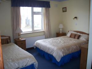 una camera d'albergo con due letti e una finestra di Seashore Lodge Guesthouse a Galway