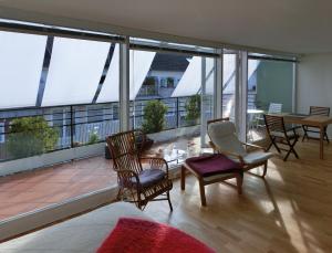 a room with chairs and a balcony with windows at Modernes, sonniges Appartement im Herzen von Düsseldorf in Düsseldorf