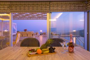 a table with a tray of fruit and a bottle of wine at Infinity Villa Kalkan in Kalkan