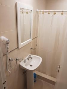 a bathroom with a sink and a shower and a mirror at Hotel Europa in Mar del Plata +69 photos
