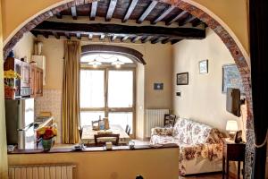 un arco en una sala de estar con sofá y ventana en Casa Billi, en Figline Valdarno