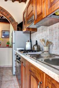 a kitchen with wooden cabinets and a stainless steel refrigerator at Casa Billi in Figline Valdarno