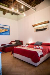 una camera con un grande letto rosso e un divano di Guest Art Napoli a Napoli