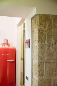 frigorifero rosso in una stanza con muro di mattoni di Guest Art Napoli a Napoli