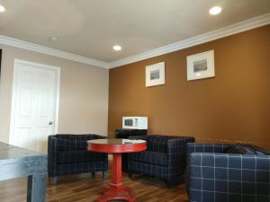 una sala de espera con sofás y una mesa roja en Bartlett Motel, en Lomita