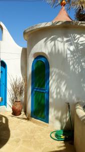 een huis met een blauw raam en een groene slang bij Torre Sabina in Vila do Maio