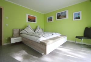 una camera da letto con un letto e pareti verdi di Ferienhaus Annemiete a Putbus