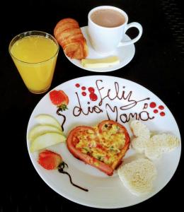 Chez Alicia Hostal في فيلا دي ليفا: طبق من الطعام مع افطار على شكل قلب مع كوب من القهوة