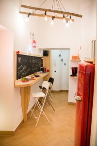 a kitchen with a table with chairs and a chalkboard at Guest Art Napoli in Naples