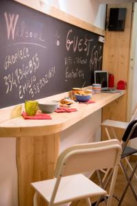 a table with chairs and a chalkboard on the wall at Guest Art Napoli in Naples
