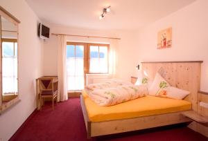 een slaapkamer met een geel bed en een raam bij Gstreinhof in Längenfeld