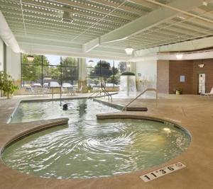 ein großer Pool mit Wasser in einem großen Zimmer in der Unterkunft Ramada by Wyndham Bettendorf in Bettendorf