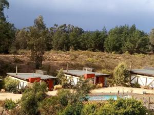 un groupe de maisons avec piscine dans un champ dans l'établissement Cabañas Toconao, à Algarrobo