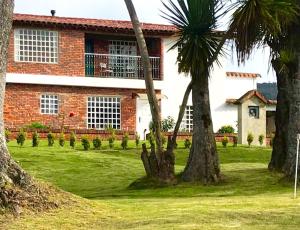 a brick house with palm trees in front of it at HOBU MONTAÑA in La Calera