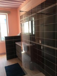 uma cozinha com uma parede de azulejos pretos em Appartement de L'Escale em Honfleur