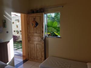 um quarto com uma porta de madeira e uma janela em Pousada Recanto do Sal em Salinópolis