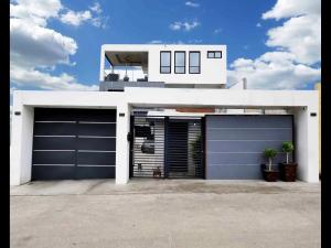 a house with two garage doors in front of it at Modern Apartment in Rosarito