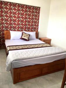 1 dormitorio con 1 cama grande y pared en Hotel Hong Anh, en Phan Rang