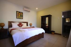 um quarto com uma cama grande e lençóis brancos em Xin Chao Hotel em Mui Ne