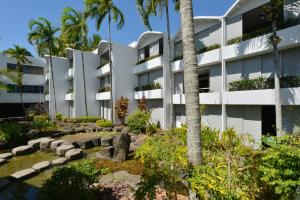 an apartment building with a garden in front of it at Seascape Holidays at Club Tropical in Port Douglas