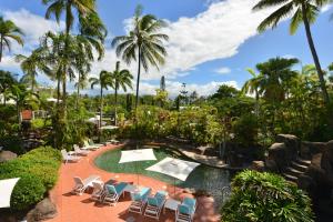 ein Resort mit einem Pool, Stühlen und Palmen in der Unterkunft Seascape Holidays at Club Tropical in Port Douglas