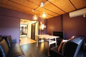 a living room with a table and leather chairs at LiB PLUS Kyoto Maiko Han-inn in Kyoto
