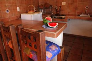 a kitchen with a table with a bowl of watermelon on it at Meson Luna Sacra in Tapalpa