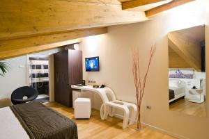 Schlafzimmer mit einem Bett, einem Schreibtisch und einem Spiegel in der Unterkunft Hotel Coppe Trieste - Boutique Hotel in Triest