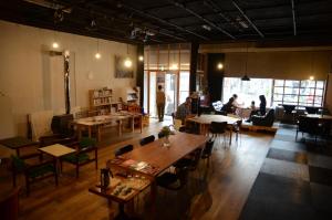 - un restaurant avec des tables, des chaises et des tables dans l'établissement Sai no Tsuno Guest House, à Ueda