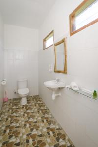 een witte badkamer met een wastafel en een toilet bij Teges Asri by Bukit Vista in Uluwatu