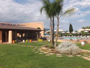 a resort with a palm tree and a swimming pool at Hotel Ristorante Al Canto delle Sirene in Terracina