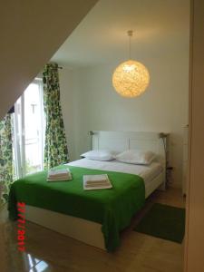 a bedroom with a bed with a green blanket at Apartments Viskovic in Makarska