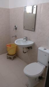a bathroom with a toilet and a sink and a mirror at Comfort Stay in Faridabad