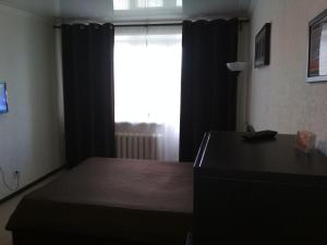 TuymazyにあるApartment on Michurina 23のベッドルーム1室(ベッド1台、デスク、窓付)