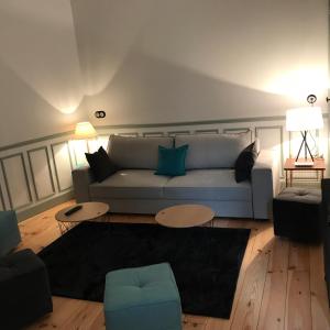 uma sala de estar com um sofá e uma mesa em La Charuel em Épernay