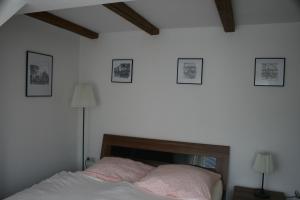 StraupitzにあるFerienhaus Straupitz-Spreewald mit Saunaのベッドルーム1室(ベッド1台付)が備わります。壁に3枚の写真が飾られています。