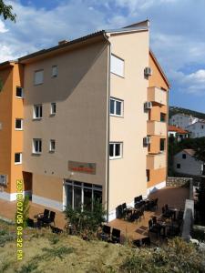 un edificio con mesas y sillas delante de él en Hostel **Casa del Sole**, en Klenovica
