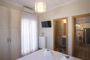 ein weißes Zimmer mit einem Bett und einem großen Fenster in der Unterkunft Casa di fiori in Lefkada Town