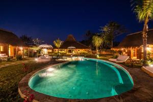 a swimming pool in a resort at night at Green Escape Eco Resort in Uluwatu