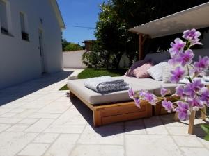 a bed on a patio with purple flowers at Casa Emilia in Umag
