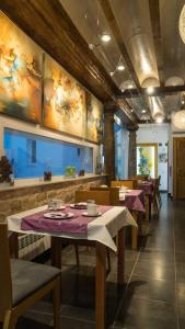 ein Restaurant mit Tischen, Stühlen und Gemälden an der Wand in der Unterkunft Hotel Boutique Arte y Descanso in Almagro
