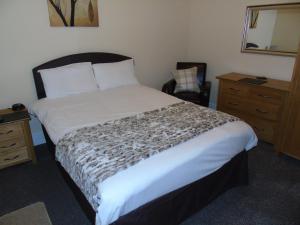 um quarto com uma cama, uma secretária e uma cadeira em Jeffersons Abbey Road Serviced Apartments em Barrow in Furness