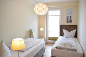ein Schlafzimmer mit einem Bett, einer Lampe und einem Fenster in der Unterkunft Villa Ocean Place in Haffkrug