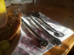 una mesa con utensilios y un sándwich en una servilleta en Pensjonat Nostalgia, en Sosnówka