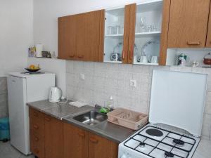 a small kitchen with a sink and a refrigerator at Kuća za odmor Matko House Matko in Pag
